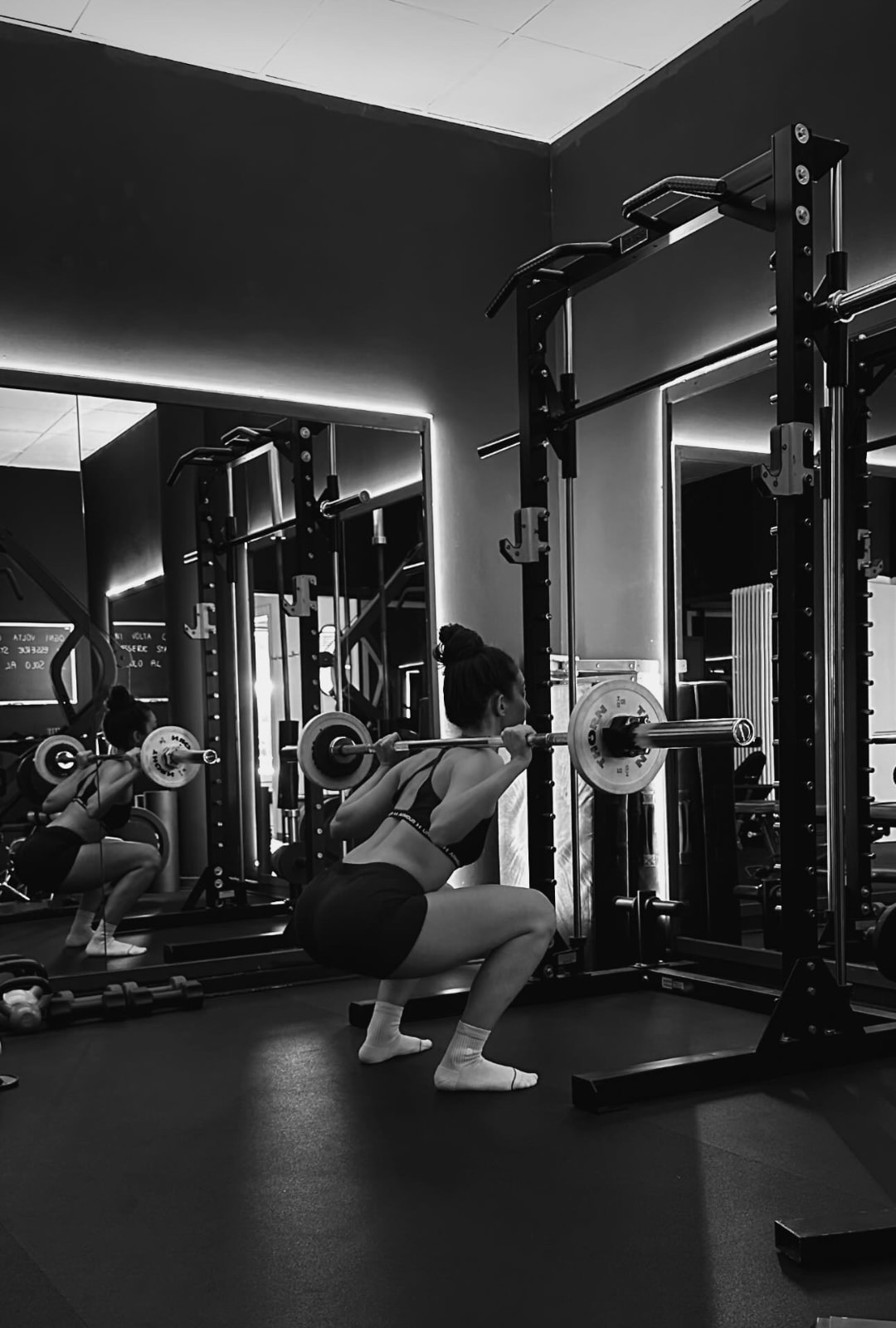 Squat con bilanciere nella sala pesi dello studio privato di Trento